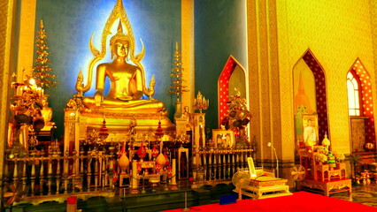 erleuchteter goldener Buddha im Wat Benchabophit Tempel in Bangkok umgeben von goldenem Glanz