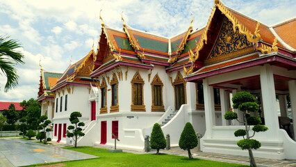 Fototapeta premium herrlicher buddhistischer Tempel Wat Benchabophit in Bangkok aus weißem Marmor mit grüner Wiese 