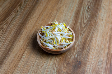 Beansprout in wooden bowl. Mungbean sprouts on wooden background.