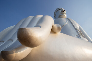 The Buddha statue in Wat Roi Phra Putthabat Phu Manorom, the most famous temple in Mukdahan,Thailand. Big Buddha statue isolated on clear sky background. © Gan