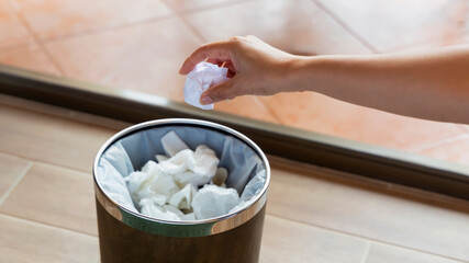 Paper Cup of coffee with recycle bin in the basket on wooden background