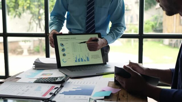 Asian businessmen having a meeting to explain the details of the project. Discussion and analysis of data, charts and graphs, business finance, and accounting concepts.