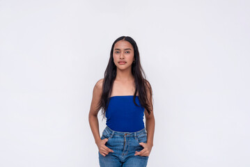 A pensive young Filipino woman in a blue tube top and jeans. Isolated on a white background.