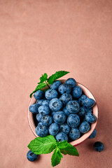 Blueberries in ceramic bowl on kraft paper. View from above