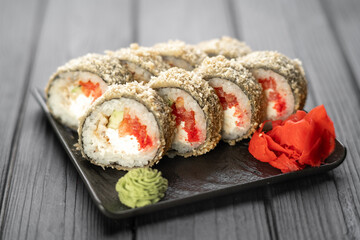 Hot fried sushi roll with salmon on black background. Sushi menu. Japanese food