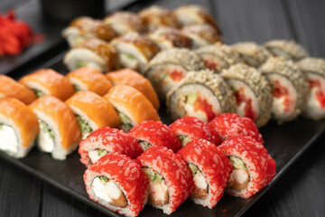 sushi set with hot rolls on the black background