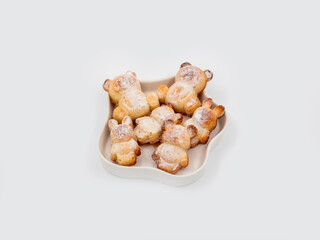 Fresh baked bunny and bear figurines cookies heap topview on white background.