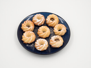 Fresh baked round coconut cookies heap top view on white background.