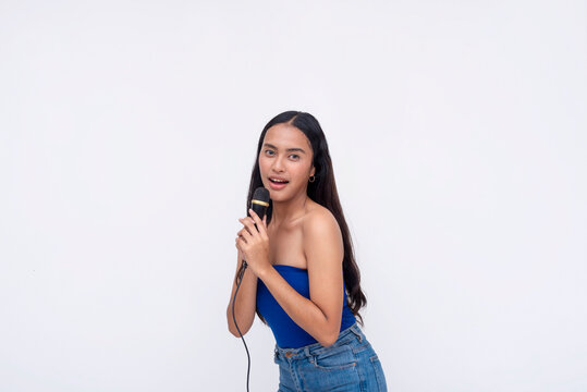 A talented young asian vocalist singing on the microphone. A pretty lady doing karaoke and having fun. Isolated on a white background.