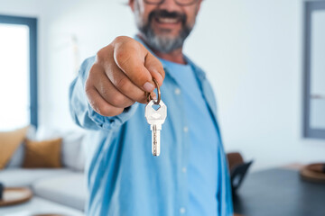 New house owner apartment buyer real estate concept business. One man holding keychains with keys...