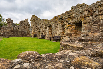Ruins of Saint Andrews Castle in Scotland and wooden benches to sit and enjoy the views.