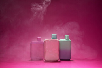 ecigarettes, disposable vape, electronic cigarettes, smoking devices in clouds of cigarette smoke on a pink background