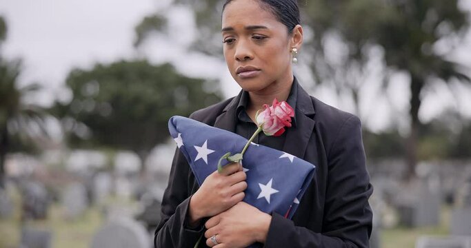 Funeral, death and rose for a woman with a flag at a cemetery in mourning at a memorial service. Sad, usa and an army wife as a widow with a flower in a graveyard feeling the pain of loss or grief