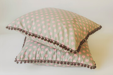 Gray cushions with pink dots on a white background.