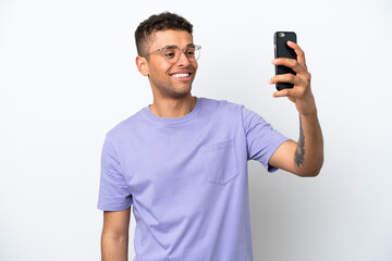 Young caucasian Brazilian man isolated on white background making a selfie