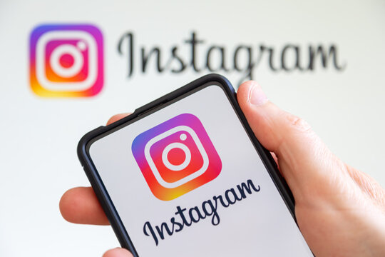 Hand holding a mobile phone with Instagram logo social media computer screen