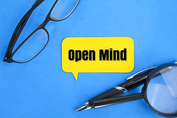 glasses, a magnifying glass and a pen with the word open mind. the concept of open or positive...