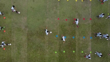 Aerial footage of an amateur football match and practice for 16 year olds in an old stadium. Aerial footage of the process of training and sparring to support children's talents in soccer - Powered by Adobe
