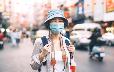 Portrait asian woman backpack traveler wear face mask at Bangkok city