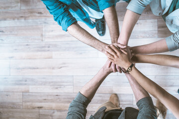 Successful business deal through close-up, top-down view of handshake. Hands of business team members shown firmly clasped in handshake gesture, symbolizing agreement, collaboration, and unity. . High