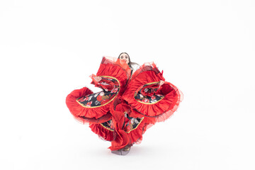 A young girl demonstrates a smart elegant red dress. Flamenco clothing. Gypsy romale style. Professional dancer isolated on white background.