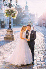 Fototapeta premium newlyweds closed their eyes and want to kiss on the old town squ