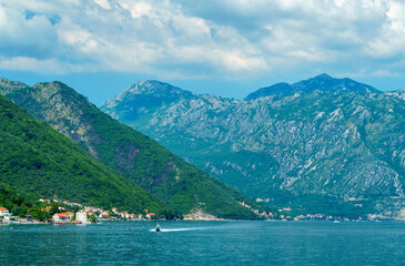 seascapes, a view of the Bay of Kotor during a cruise on a ship in Montenegro, a bright sunny day, mountains and small towns on the coast, the concept of a summer trip