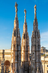 Fototapeta na wymiar The spires and pinnacle sculptures on the roof of the Milan Cathedral