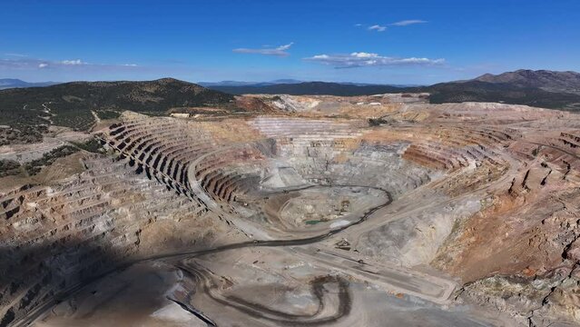 Aerial open pit gold copper mine Ely Nevada slide 1. Boom town along historic Pony Express trail. Rural mining community. Ore transported to Japan for smelting. Precious minerals.