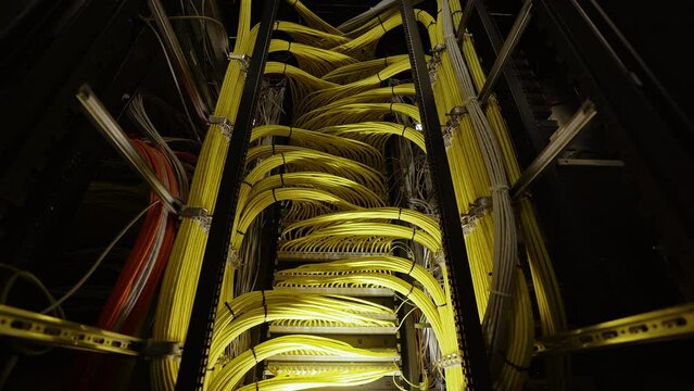 Top view of a large bundle of yellow wires in a large server room.
