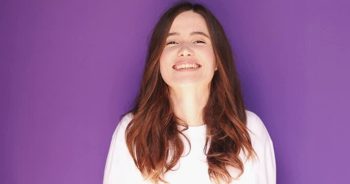 Smiling happy young brunette girl wears white long sleeves scream hot news about sales discount with hands near mouth isolated on purple background. Lifestyle emotions, announce. Attention! Sale!