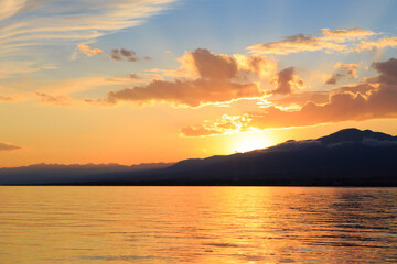 Colorful sea beach over mountains sunrise with deep blue sky and sunbeams. natural background