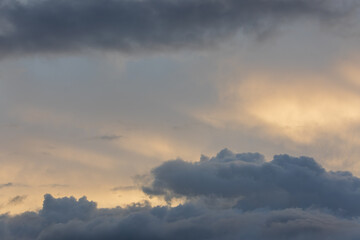Sunset sky with majestic black clouds floating around.