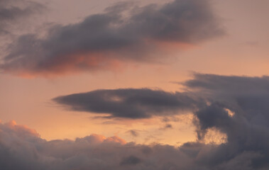 Fototapeta na wymiar At sunset, an orange sky with majestic dark clouds.