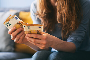 Woman counting Euro cash at home - obrazy, fototapety, plakaty