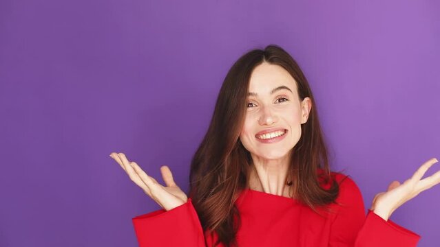 Unbelievable offer. Young surprised woman in red pullover touching cheeks, opening mouth in amazement, expressing disbelieve and excitement isolated on purple studio background. Wow emotions!