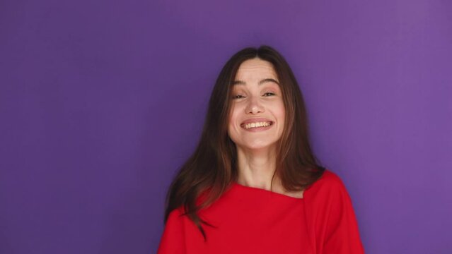 Smiling happy young brunette girl wears red sweater scream hot news about sales discount with hands near mouth isolated on purple background. Lifestyle emotions, announce. Attention!