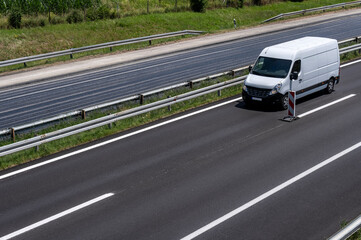 White modern delivery small shipment cargo courier van moving fast on motorway road to city urban suburb.	