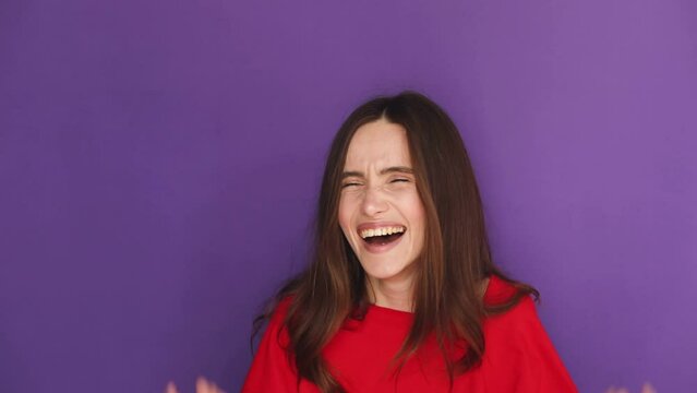 Young excited cheerful funny brunette woman look camera laugh smiling watch comedy movie, listening joke, pointing index finger on you isolated on purple violet background studio portrait