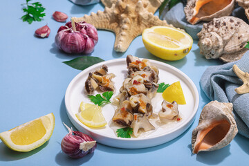 Pickled rapan meat with oil, spices and greens. Healthy seafood rich of omega