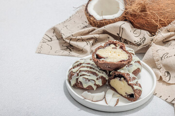 Profiteroles choux pastry buns with coconut cream served in tropical style. Palm leaves