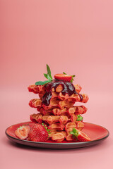 Homemade Belgian Waffles with strawberries. Gluten-free red dessert, fresh fruits and basil