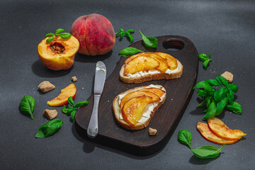 Fresh bread sandwiches with sweet peach slices, cream cheese and basil leaves. Good morning concept