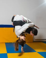 Foto op Aluminium Young girl and boy practice Brazilian jiu jitsu in the gym © Дмитро Петрина