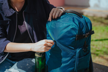 close up a woman's hand is opening her backpack