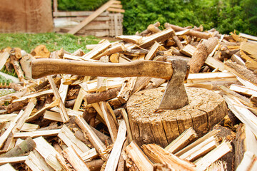 Ax and firewood in the yard, Ax in the stump, Pile of firewood and tree stump, Firewood for the winter,