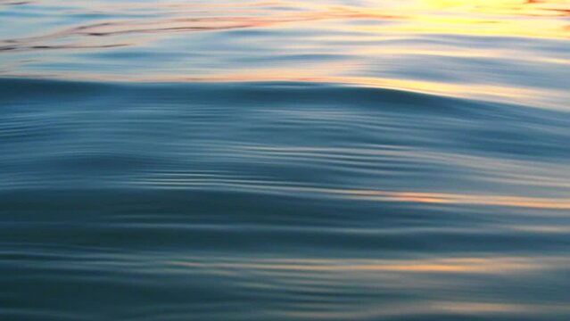 Calm Water With Ripples And Smooth Waves. Water Texture. Water Surface. Soft Waves Ripples At Golden Hour In The Evening. Spontaneous Generation Of Waves. Solar Path On The Water At Sunset.