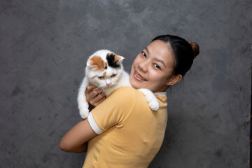 Asian girl hugging a cat to show love for pets. Love for domestic pets.