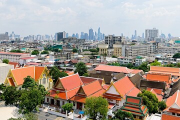 Traditional Thai Architecture with Modern Buildings and Skyscrapers in Background and poor area in the middle of the photo.