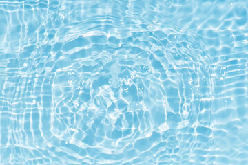 Blue water with ripples on the surface. Defocus blurred transparent blue colored clear calm water surface texture with splashes and bubbles. Water waves with shining pattern texture background.